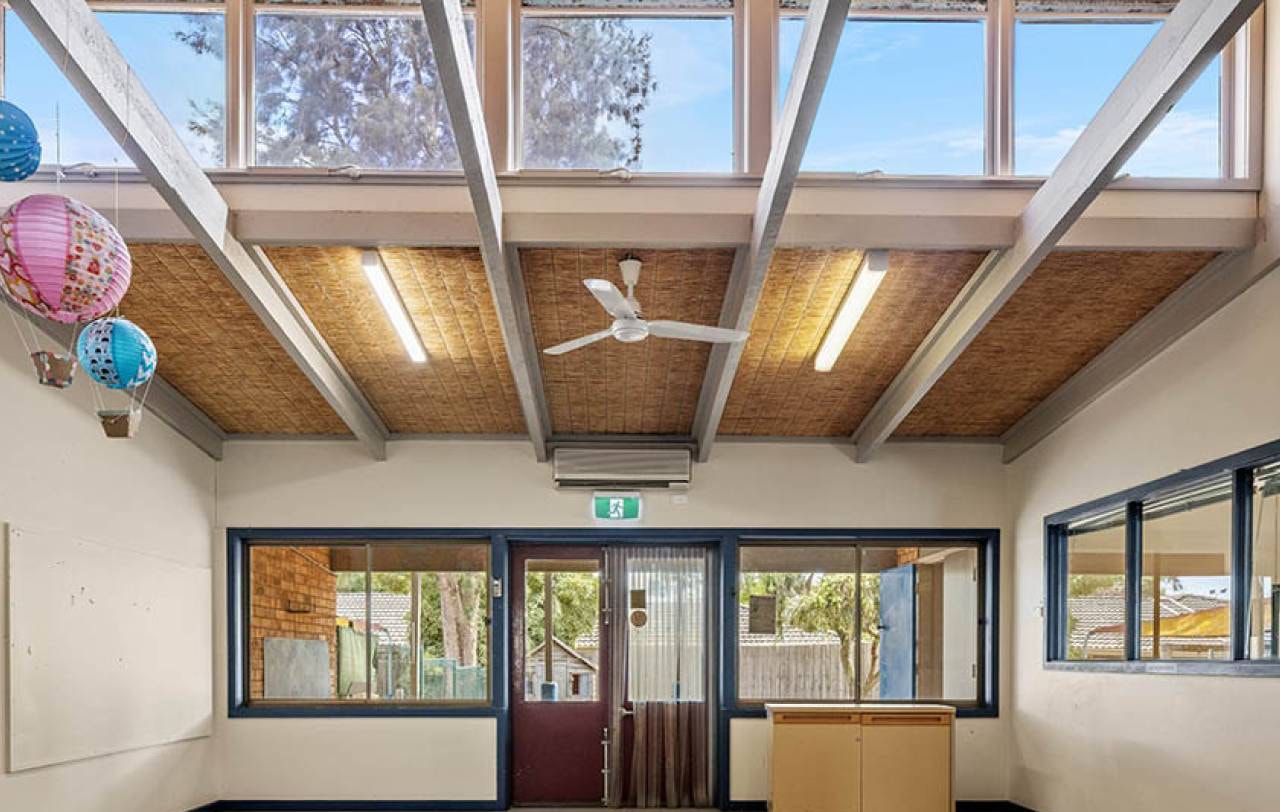 Interior room with exposed timber rafters, clerestory windows and a lined ceiling.
